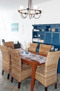凯斯特海伊Bajcsyház Apartman的一间带木桌和藤椅的用餐室