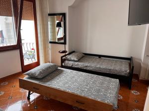 阿纳卡普里Casa Dora的客房设有两张床、一张桌子和一扇窗户。