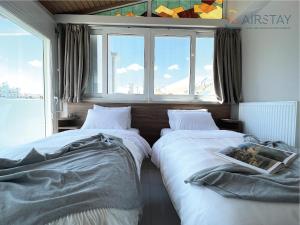斯巴达Akali Apartment airport by Airstay的带窗户的客房内的两张床