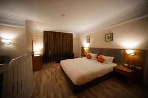 亚的斯亚贝巴Mado Hotel的酒店客房带一张大床,带两个橙色枕头