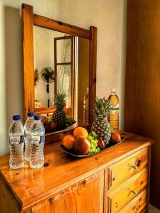 圣斯特凡诺斯Katerina's Apartments的木质梳妆台,上面装有水果和水瓶