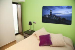 圣地亚哥－德孔波斯特拉霍塔斯公寓的卧室配有白色床和紫色枕头