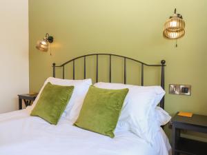 克雷迪顿Nelli Lodge at Mile End的一间卧室配有带白色床单和绿色枕头的床。