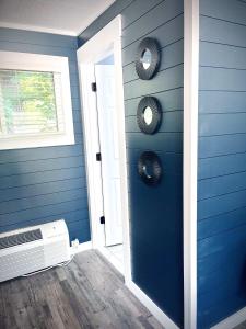 RoscommonModern Room 12-Newly Renovated的一间设有蓝色墙壁的客房和一扇带风扇的门