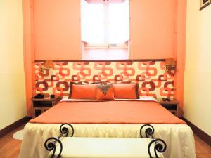 利马利马瓦瑞精品酒店的一间卧室配有一张带橙色床头板的大床