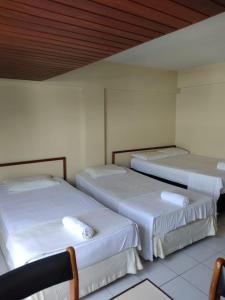 若昂佩索阿Manos Flat Tambaú - ap 111的白色墙壁的客房内的三张床