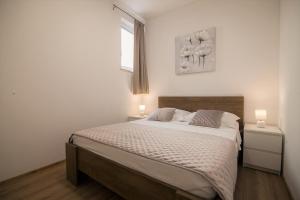 波尔Apartments Teskera的一间卧室配有一张大床,上面有两盏灯
