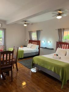 圣乔治拉赫里科尼亚酒店&日间水疗中心的一间卧室配有两张床和一张桌子及椅子