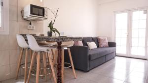 马斯帕洛马斯BUNGALOW LOS ARCOS的客厅配有沙发和带凳子的桌子