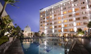 日惹The Rich Jogja Hotel的大楼前有游泳池的酒店