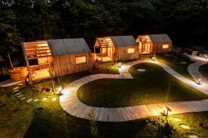 Bistrica pri TržičuGlamping Mountain Fairy Tale的后院在晚上设有木制小屋和灯