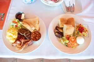 圣乔治拉赫里科尼亚酒店&日间水疗中心的桌上的两盘早餐食品
