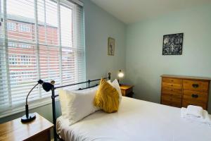 谢菲尔德Historic Kelham House with FREE on-site Parking的一间卧室配有一张黄色枕头的床