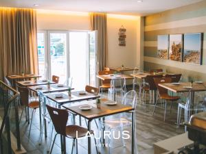 劳林哈Laurus Hotel的用餐室设有桌椅和窗户。
