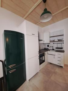 比尔古Ta' Wenzu的厨房配有绿色冰箱和白色橱柜