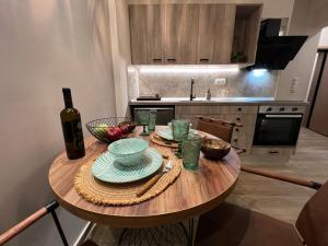 亚历山德鲁波利斯Supreme Malibu Suite的厨房配有木桌和一瓶葡萄酒