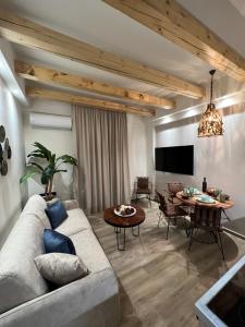 亚历山德鲁波利斯Supreme Malibu Suite的客厅配有沙发和桌子