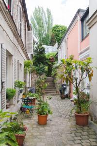 巴黎Le Grand Maulnes的一条种有盆栽植物和楼梯的小巷