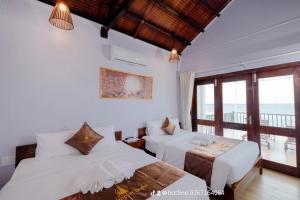 富国The Poplar Resort Phú Quốc的一间带两张床的卧室和一个阳台