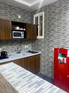 塔伊夫أفنان بارك شقق فندقية的厨房配有红色冰箱和微波炉