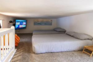 布拉格堡H - Crab Shack的一间卧室配有两张床和一台平面电视
