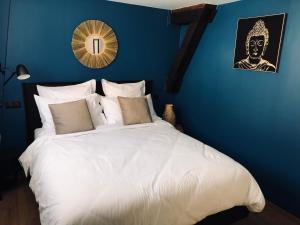 费康Escale à Fécamp 4 étoiles - garage privé的一间卧室配有一张白色大床和蓝色的墙壁
