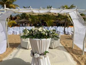 萨利波图尔Movenpick Resort Lamantin Saly的海滩上的婚礼仪式,带白色椅子