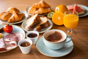 莫尔塞姆Hôtel Diana Restaurant & Spa by HappyCulture的餐桌,早餐盘和咖啡盘
