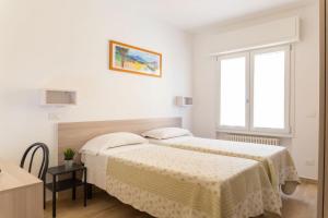里乔内Affittacamere Ceccarini的白色的客房设有两张床和窗户。