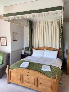 诺里奇Arrandale Lodge的一间卧室配有一张天蓬床和两张毛巾