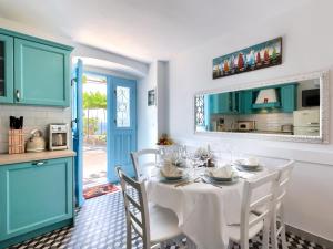 拉宾Holiday Home Casa Di Nelo by Interhome的用餐室配有带白色椅子的桌子和蓝色橱柜