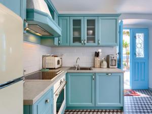 拉宾Holiday Home Casa Di Nelo by Interhome的厨房配有蓝色橱柜和水槽