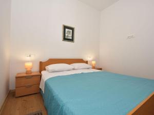 维利伊兹Holiday Home House of pleasant dreams by Interhome的一间卧室配有一张带蓝色床罩和两盏灯的床。