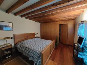 BoscoHoliday Home Villa La Chiesa by Interhome的一间带一张床的卧室,位于带木制天花板的房间内