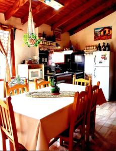 埃尔卡拉法特Cabaña Onty的一间带桌椅的厨房和一间带冰箱的厨房