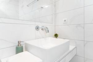 萨索斯Aenaon studios的白色的浴室设有水槽和白色瓷砖