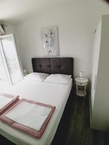 格拉达茨Tonka Apartments的卧室配有一张大白色床和窗户