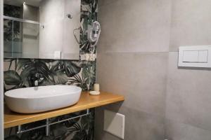 萨萨里Hermitage Suites的浴室设有白色水槽,墙上种植了植物
