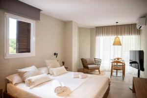 埃斯普霍斯Boho Suites Formentera的卧室配有一张白色的大床和一张桌子