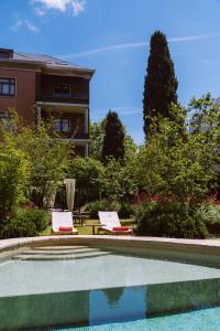 巴塞罗那普里梅罗第一酒店的一个带两把椅子的游泳池以及一座房子
