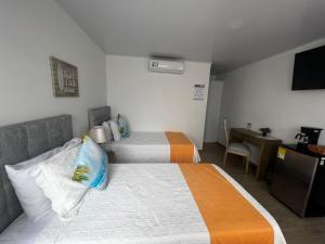 圣安德烈斯Hotel Mar de Corales By CAJASAI的酒店客房配有两张床和一张书桌