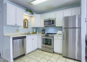 格尔夫海岸Gulf Shores Plantation Condos的厨房配有白色橱柜和不锈钢冰箱