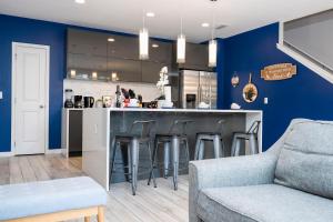 基西米Enchanting Four Bedrooms Townhouse at Le Reve Resort (211021)的厨房设有蓝色的墙壁和带凳子的酒吧。