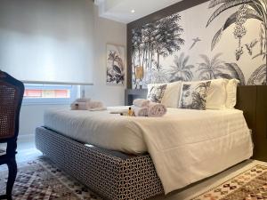 萨萨里Hermitage Suites的一间卧室配有一张带白色床单的大床