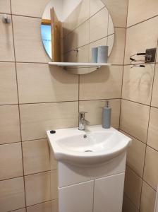沙罗什保陶克Balogh Vendégház的浴室设有白色水槽和镜子