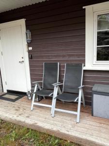 DrangedalLeilighet på Gautefall的两把椅子坐在房子前门廊上
