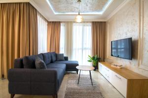 普罗夫迪夫Odrys Apartments的客厅配有蓝色的沙发和电视
