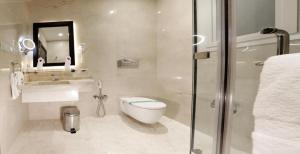 利雅德利雅德阿斯沃套房酒店的浴室配有卫生间、盥洗盆和淋浴。