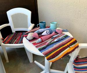 帕琉乔拉BONATSA ROOMS的一张带毯子的白色桌子和两杯及一把椅子