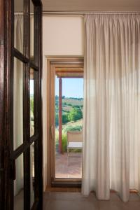 马利亚诺因托斯卡纳Casale Sterpeti的客房设有门和美景窗户。